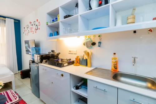 a kitchen with blue and white cabinets and a sink at Gracie's Cosy Residence in Kiambu
