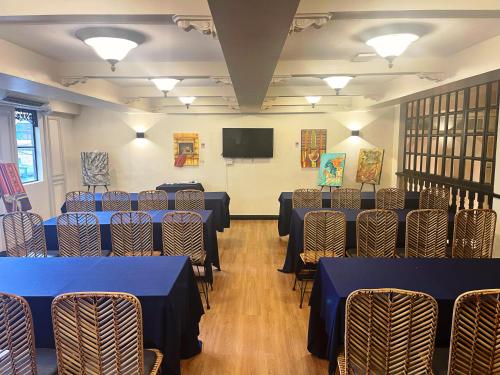 a room with tables and chairs and a flat screen tv at Airo Hotel Manila in Manila