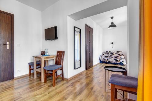 a living room with a table and chairs and a television at Willa Wladyslaw - centrum Krynicy, parking w cenie! in Krynica Zdrój