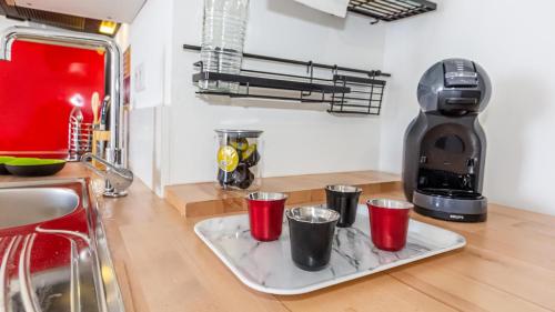 a tray with red solo cups on a kitchen counter at Ti jacques location - Saint-Gilles les bains - studio pour 2 personnes in Saint-Paul