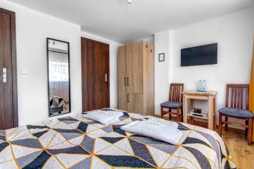 a bedroom with a bed and two chairs in it at Willa Wladyslaw - centrum Krynicy, parking w cenie! in Krynica Zdrój