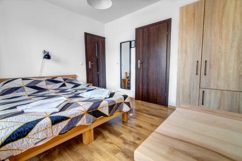 a bedroom with a bed and a wooden cabinet at Willa Wladyslaw - centrum Krynicy, parking w cenie! in Krynica Zdrój