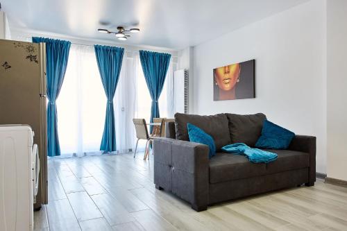 a living room with a couch and blue curtains at Apartamente Nord 10 in Năvodari