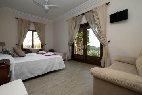 a hotel room with two beds and a couch at El palacete in Estepona