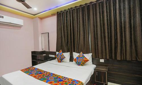 a bedroom with two beds and a window with curtains at FabExpress Banarasi Kothi in Varanasi