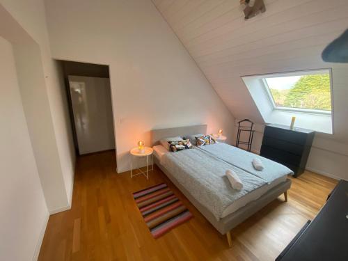 a bedroom with a bed and a window in a attic at Le Onze Soixante Six Duplex très ensoleillé in Perroy