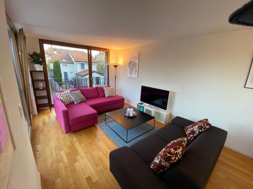 a living room with a couch and a tv at Le Onze Soixante Six Duplex très ensoleillé in Perroy