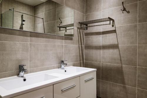 een badkamer met een wastafel en een spiegel bij Hotel Du Dauphiné in Lyon