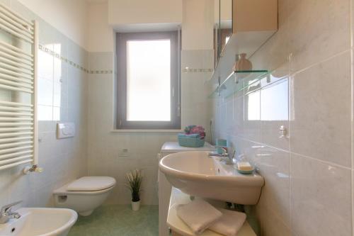 a white bathroom with a sink and a toilet at Appartamento Galileo Deluxe - MyHo Casa in Tortoreto Lido