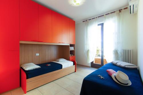 a bedroom with two beds and red cabinets at Appartamento Galileo Deluxe - MyHo Casa in Tortoreto Lido