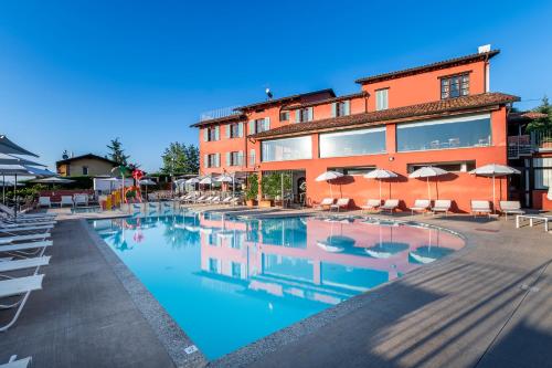 ein Hotel mit einem Pool vor einem Gebäude in der Unterkunft Ai Tardì in Diano dʼAlba