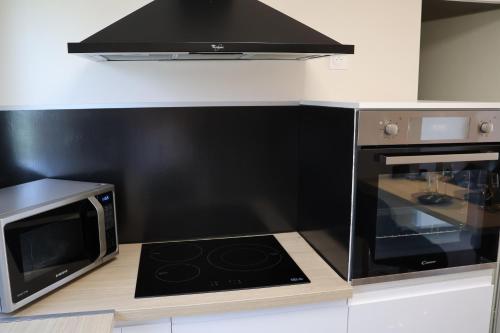 a kitchen with a stove and a microwave at Les gîtes coquins in Amilly