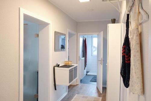Cette chambre dispose d'un couloir avec un lavabo et une porte. dans l'établissement Ferienwohnung Bergischer Panoramasteig, à Radevormwald