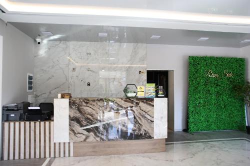a lobby with a marble wall and a counter at RIVER SIDE in Polyana
