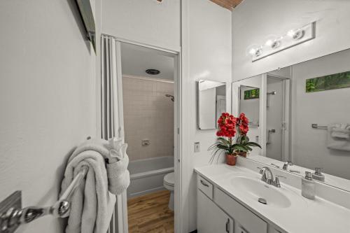 a white bathroom with a sink and a mirror at Newly Upgraded 1BR Unit Near Beach max of 5 Guests in Kailua-Kona