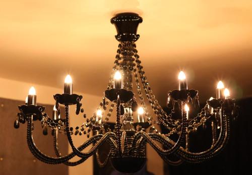 a chandelier with lights hanging from a ceiling at Les gîtes coquins in Amilly