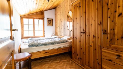 een slaapkamer met een bed in een houten hut bij Gemütliches Ferienhaus Brigerbad in Brigerbad