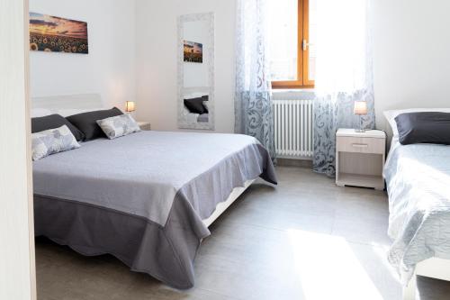 a bedroom with two beds and a window at Appartamento il Melograno in Rapolano Terme
