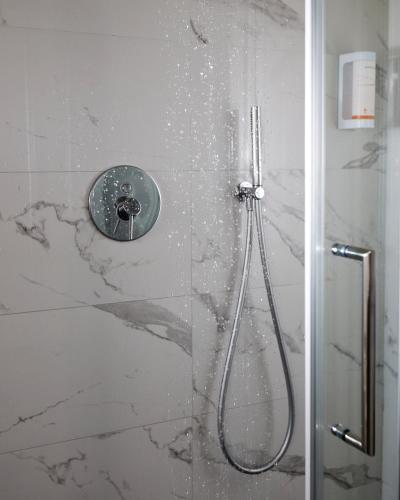 ducha con puerta de cristal y ducha en B&B Funtanin, en Cuggiono