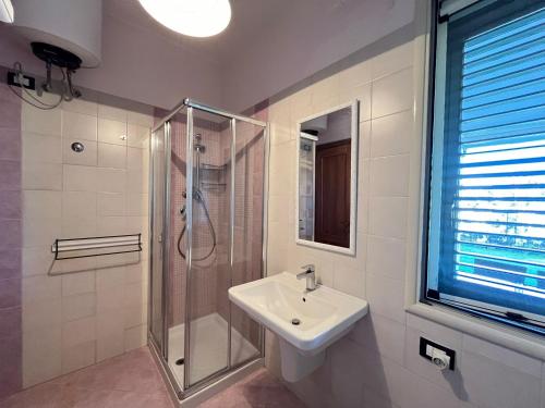 La salle de bains blanche est pourvue d'une douche et d'un lavabo. dans l'établissement Summer house, à Avola