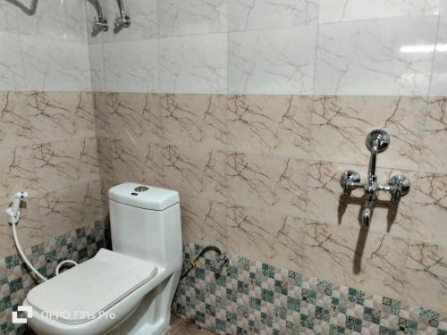 Łazienka z toaletą i marmurową ścianą w obiekcie PATHI BUNKERS w mieście Dardżyling