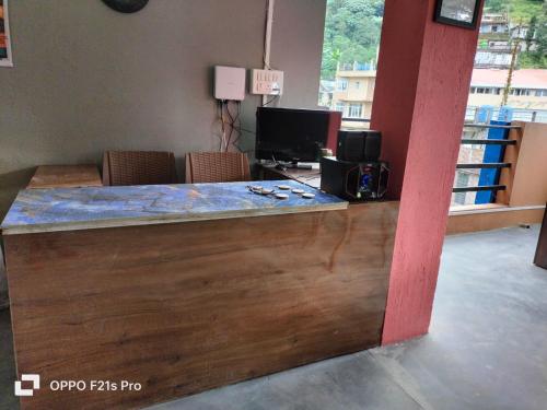 a counter in a room with a desk with a television at PATHI BUNKERS in Darjeeling