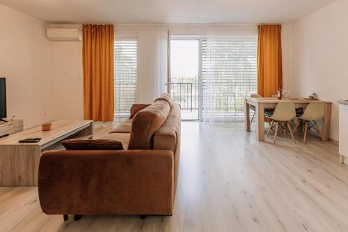 uma sala de estar com um sofá e uma mesa em Sunrise Apartments em Senec