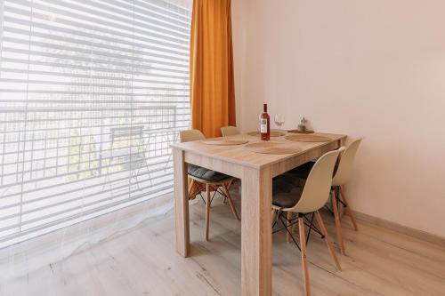 a dining room table with a bottle of wine on it at Sunrise Apartments in Senec