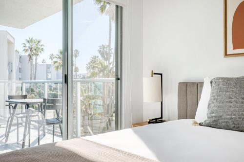 een slaapkamer met een bed en een balkon met een tafel bij Redondo Beach 1BR w Pool Gym WD nr Beach LAX-614 in Redondo Beach