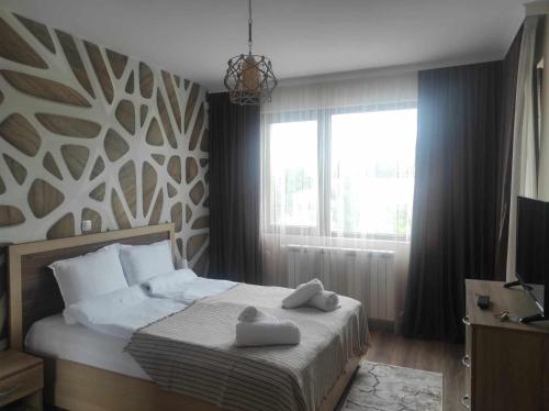 a bedroom with a bed with two towels on it at Апартамент Четири сезона 2 in Velingrad