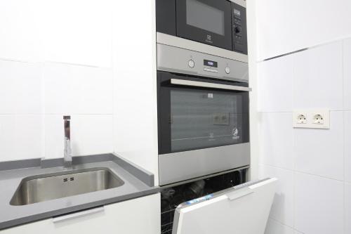 uma cozinha com um lavatório e um micro-ondas em Sol Apartment Deluxe-Nuñ-Arce em Madrid