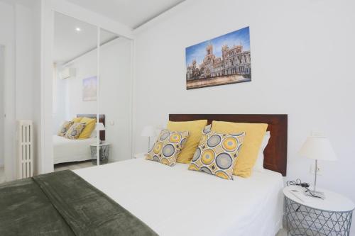 マドリードにあるSol Apartment Deluxe-Nuñ-Arceの白いベッドルーム(大型ベッド1台、黄色い枕付)