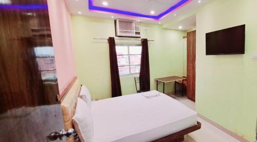 a hospital room with a bed and a tv at Hotel Ananya Inn in Varanasi