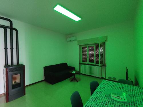 a green room with a fireplace and a table and chairs at Casa Zoe in Piacenza