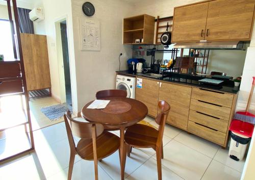 a small kitchen with a wooden table and chairs at Timurbay Seafront Residence & Suites in Kuantan