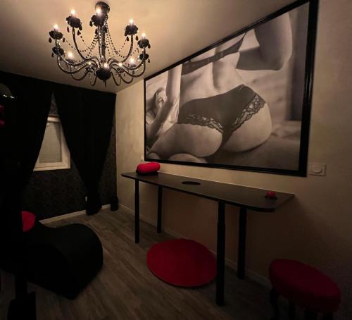 a room with a table and a large painting on the wall at Les gîtes coquins in Amilly