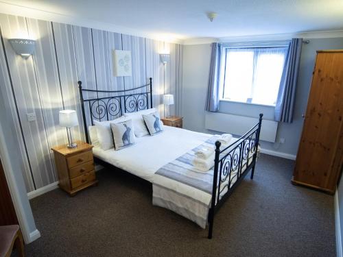 a bedroom with a bed with a black frame and a window at The Heath Inn in Leighton Buzzard
