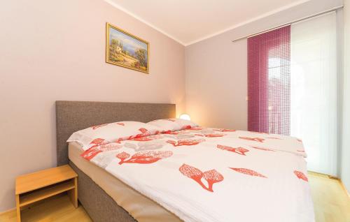 a bedroom with a bed with a bedspread with shoes on it at Apartments Stojanovic in Vir