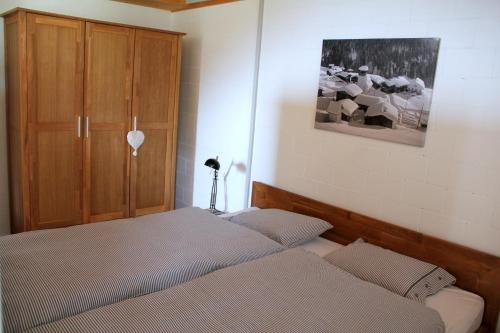 a bedroom with two beds and a wooden cabinet at Hotel Ducan in Monstein