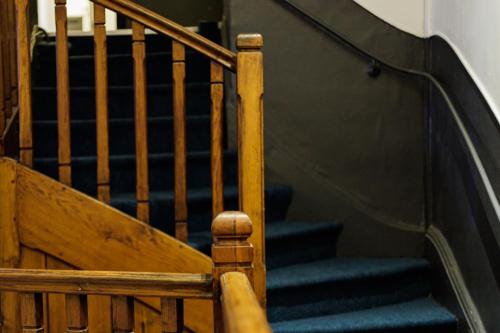 a set of stairs with blue carpet and a wooden railing at Hotel Du Dauphiné in Lyon