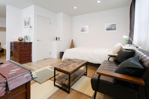 a living room with a bed and a couch at 金澤屋　昭和町 in Kanazawa