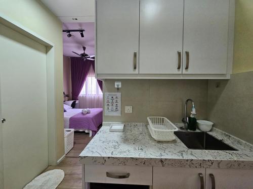 a kitchen with a sink and a room with a bed at Oasisstay 4 Bedrooms Apartment With Studio at Bangi Sentral in Bandar Baru Bangi