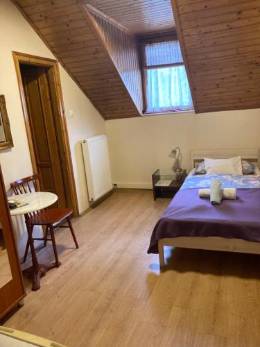 a bedroom with a bed and a wooden ceiling at Retro Panzió in Pécs