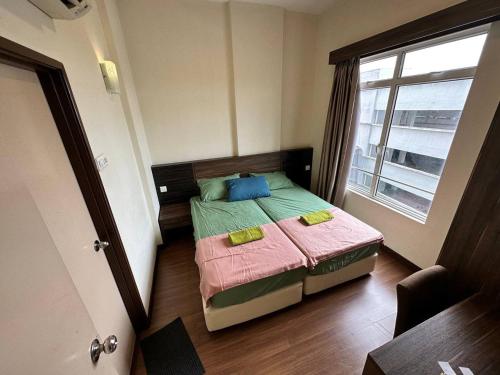 a small bedroom with a bed and a window at Junikastay BLagoon Melaka in Melaka