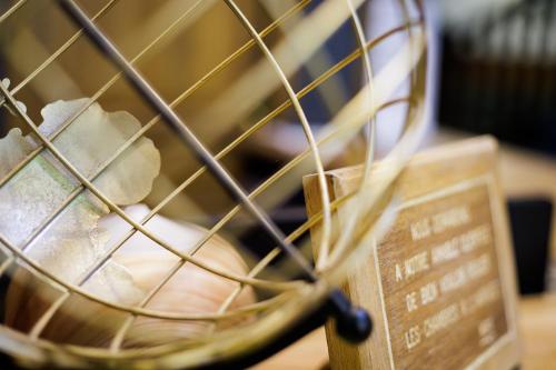 a close up of a wire basket with a sign at Hotel Du Dauphiné in Lyon