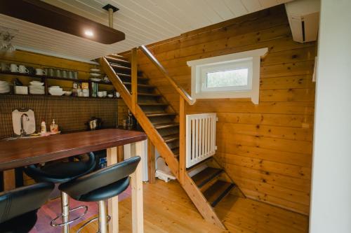 a room with a staircase and a table and chairs at Kõhe Talu Puhkemaja in Rämsi