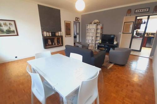 un salon avec une table et des chaises blanches dans l'établissement Appartement calme, lumineux et spacieux. Angers., à Angers