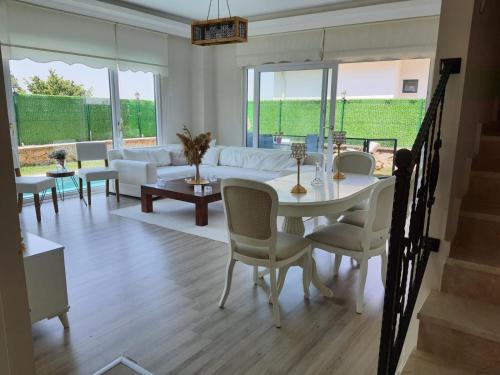 sala de estar con mesa blanca y sillas en Villa Mila, en Kartepe