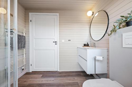 a bathroom with a white door and a mirror at Cosy Cabin on the Golden Circle in Selfoss