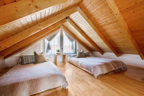 two beds in a attic room with wooden ceilings at Cosy Cabin on the Golden Circle in Selfoss